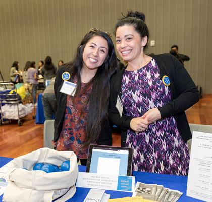 Two female Chicanx/Latinx students at a banquet